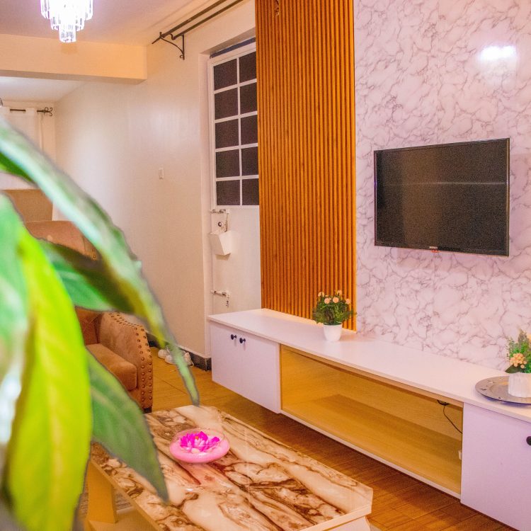 TV and lounge area inside The Moon Serenity 2-bedroom furnished apartment at Thindigua Branch, featuring a modern living room, comfortable seating, and stylish interior décor.